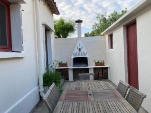 a patio with two chairs and a fireplace on a building at Maison 10 personnes 250m plage in Canet-en-Roussillon