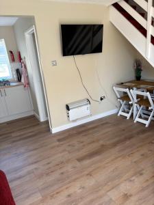 a living room with a fan and a tv on the wall at 63 Bermuda in Hemsby
