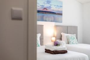 a hotel room with two beds with towels and a painting at GuestReady - Passal Guesthouse in Ponta Delgada