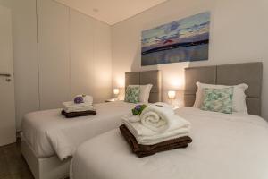 two beds with towels on them in a bedroom at GuestReady - Passal Guesthouse in Ponta Delgada