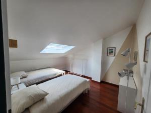 two beds in a white room with a skylight at Villa Mahloa in Saint-Yaguen +29 photos
