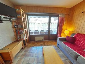 a living room with a couch and a large window at Studio cosy 4 pers, centre village, parking, ascenseur, balcon - Le Grand-Bornand - FR-1-241-185 in Le Grand-Bornand