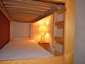 a bedroom with a wooden bunk bed with a lamp at Studio cosy 4 pers, centre village, parking, ascenseur, balcon - Le Grand-Bornand - FR-1-241-185 in Le Grand-Bornand