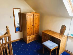 a room with a wooden cabinet and a desk and a chair at Thaxted Bed & Breakfast and Accommodation in Thaxted