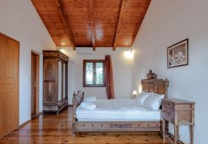 a bedroom with a bed and a wooden ceiling at Teacher Cottage in Agia Triada +19 photos