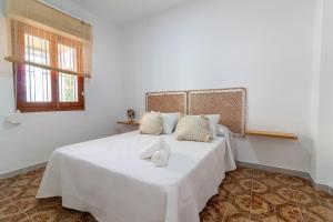 a bedroom with a white bed with two towels on it at Global Properties, Les Villetes - Magdalena in Moncófar