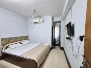 a bedroom with a bed and a flat screen tv at Hotel mountain rangpo in Jāmb