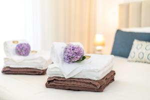 a pile of towels with a flower on top of them at GuestReady - Passal Guesthouse in Ponta Delgada