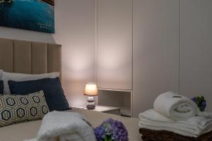 a bedroom with towels on a bed with a lamp at GuestReady - Passal Guesthouse in Ponta Delgada +8 photos