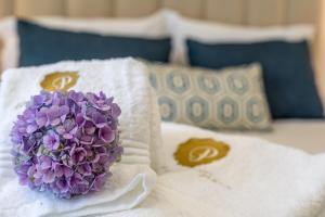 a purple flower sitting on top of towels on a bed at GuestReady - Passal Guesthouse in Ponta Delgada