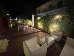 a patio with a table and chairs at night at Alessandra House in Grottammare