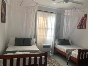 ein Schlafzimmer mit zwei Betten und einem Fenster in der Unterkunft Three bedroom in aqua nyali in Mombasa + 15 Fotos