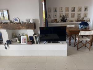 - un salon avec une télévision à écran plat assise sur un comptoir dans l'établissement Villa Shasa, à Talamone