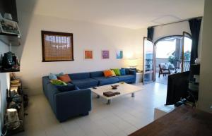 un salon avec un canapé bleu et une table dans l'établissement Villa Shasa, à Talamone