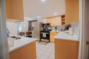 a kitchen with wooden cabinets and white counter tops at Cowboy Den-Hot Tub-Game Room-Pet Friendly-No Pet Fees! in Albuquerque