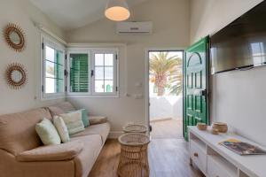una sala de estar con un sofá y una mesa en Cotillo Beachfront Escape, en La Oliva