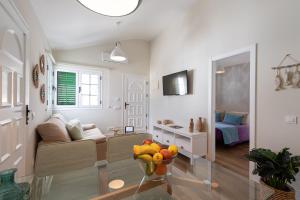 una sala de estar con sofá y un bol de fruta en una mesa en Cotillo Beachfront Escape, en La Oliva