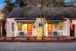 una casa bianca con porte rosse e bandiere americane di Hot Tub - Historic District - Next to Forsyth Park a Savannah