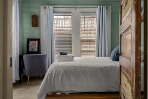a bedroom with a white bed and a window at Hot Tubs - DT Duplex - Two Blocks off Forsyth Park in Savannah