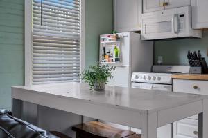a kitchen with a large white table in a kitchen at Hot Tubs - DT Duplex - Two Blocks off Forsyth Park in Savannah