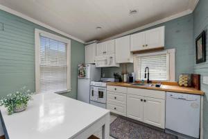 a kitchen with white cabinets and a white refrigerator at Hot Tubs - DT Duplex - Two Blocks off Forsyth Park in Savannah