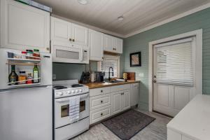 a kitchen with white cabinets and white appliances at Hot Tubs - DT Duplex - Two Blocks off Forsyth Park in Savannah +50 photos
