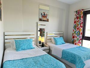 une chambre avec deux lits avec des draps bleus et blancs dans l'établissement Apartment at Marassi, à El Alamein