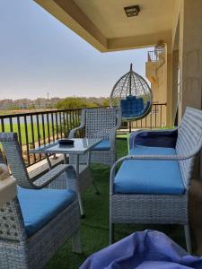 d'un balcon avec des chaises, une table et une balançoire. dans l'établissement Apartment at Marassi, à El Alamein 6 autres photos