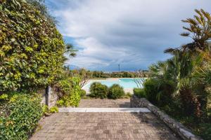 a walkway leading to a swimming pool in a resort at La Terrazza sul Lago - Splendida Vista sul Garda in Raffa