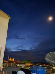 a night view of a city with a moon at Mahaidana Kitnet in São Thomé das Letras