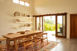 una sala da pranzo con tavolo e sedie in legno di Villa August Lombok a Selong Belanak