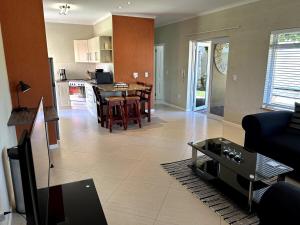 a living room and kitchen with a table and chairs at Sandy Greens Villa in Swakopmund +16 photos