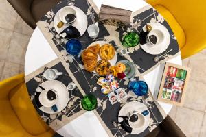 a table with plates and cups and glasses on it at Hotel Dalì in Scafati