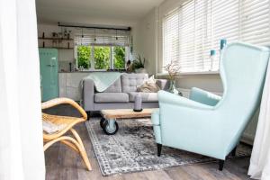 a living room with a blue chair and a couch at Strand-chalet Luna - 700 mtr van het strand van Ouddorp in Ouddorp