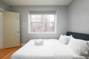 a white bed in a room with a window at Luxurious 1BR unit in Montreal in Montréal