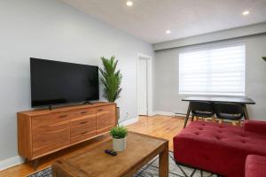 a living room with a red couch and a flat screen tv at Sunny 2BR unit in Montreal in Montréal
