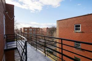 a balcony with a black railing next to a brick building at Sunny 2BR unit in Montreal in Montréal