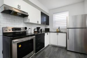 a kitchen with black and stainless steel appliances at Sunny 2BR unit in Montreal in Montréal +9 photos