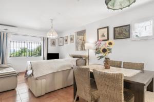 a dining room with a table and a couch at Villa Rosario in El Bosque