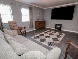 a living room with a couch and a flat screen tv at Shalom Apartment 100A in Armagh