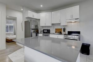 a kitchen with white cabinets and a large counter top at The NDG Escape Prime Location and Cozy Stay in Montréal