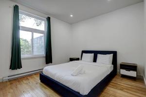um quarto com uma cama grande e uma janela em The NDG Nest A Relaxing 3BR Getaway in DT MTL em Montréal