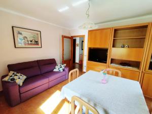 a living room with a purple couch and a table at Appartamento Sole in Mezzana