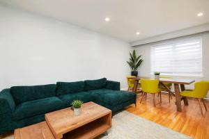 Una sala de estar con un sofá verde y una mesa. en Stylish 2BR in Montreal, en Montreal 11 fotos más