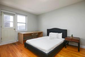 a bedroom with a bed and a desk and a window at Beautiful 2BR on Walkley in Montréal