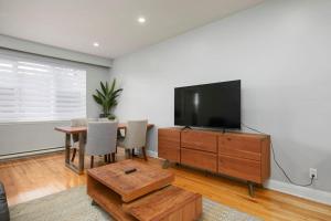 sala de estar con TV y mesa con sillas en Amazing 2BR on Walkley, en Montreal