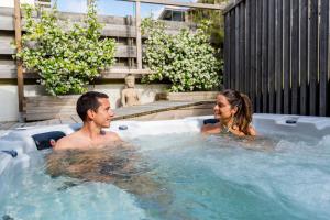 a man and a woman in a hot tub at Ted Surf House in Capbreton