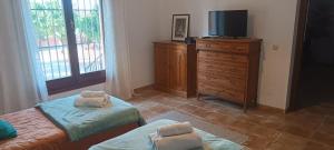a bedroom with two beds and a tv on a dresser at casa sierrecilla in Fuente de Piedra +28 photos
