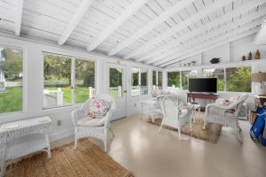 a room with white chairs and a tv and windows at 89 Gorham Road Harwich Port - Sweet Retreat in Harwich Port