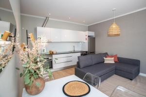 a living room with a couch and a kitchen at Casa do Gaveto in Água de Pau +21 photos